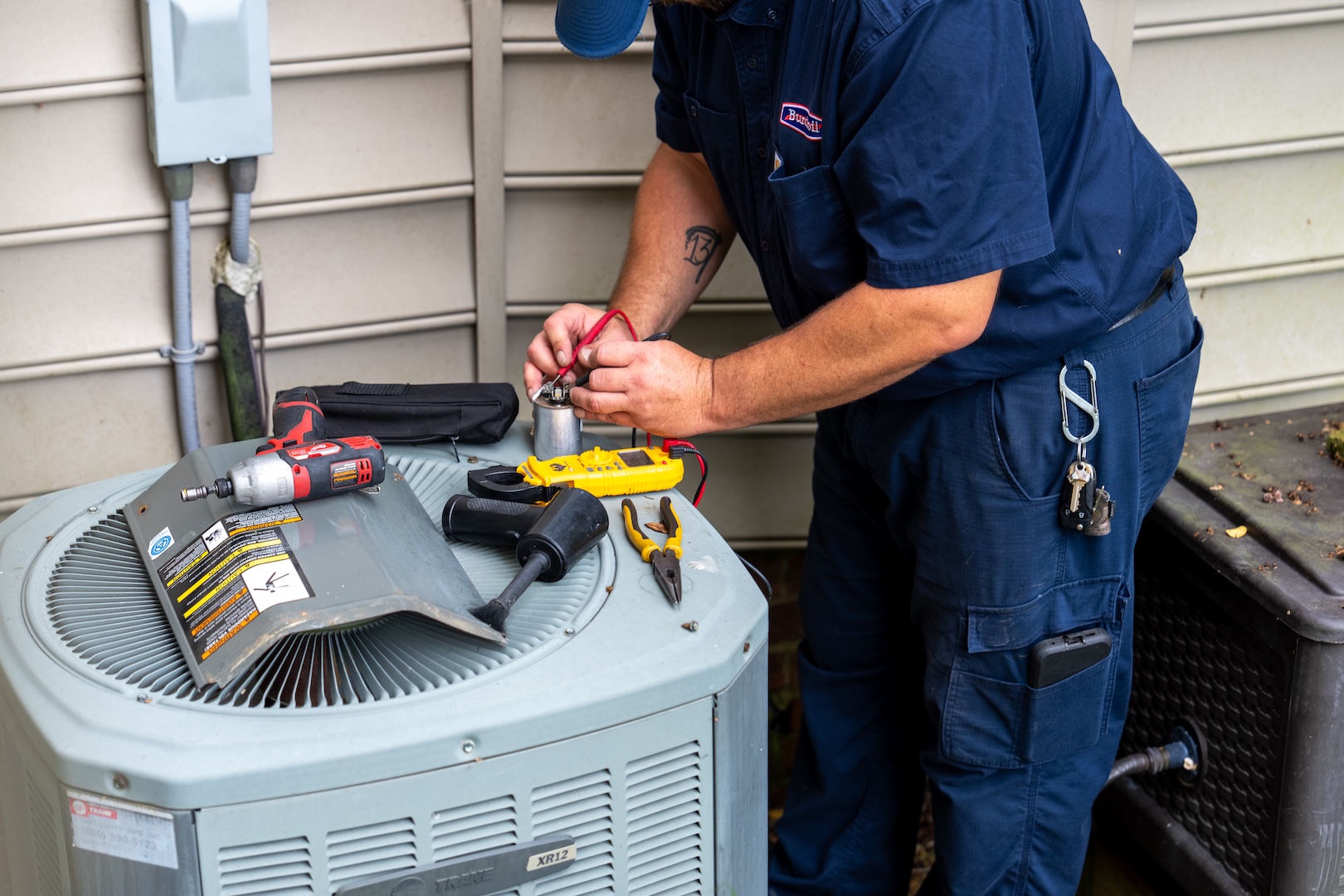 Burch technician working on an outdoor heating/air conditioning unit.