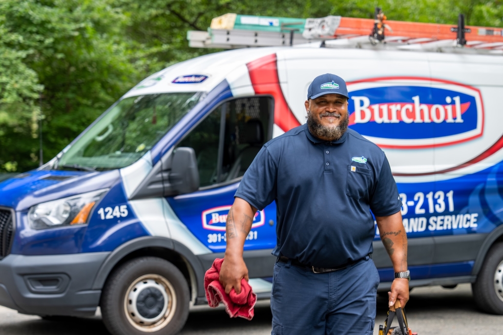 Burch technician smiling and walking with tools