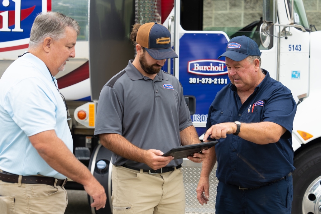 Burch Oil & Propane team members looking at a tablet to review HVAC, propane and heating oil accounts.