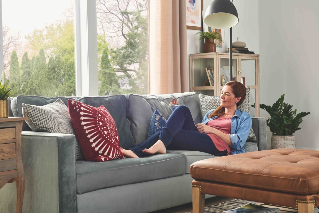 woman on couch relaxing in her warm, cozy home