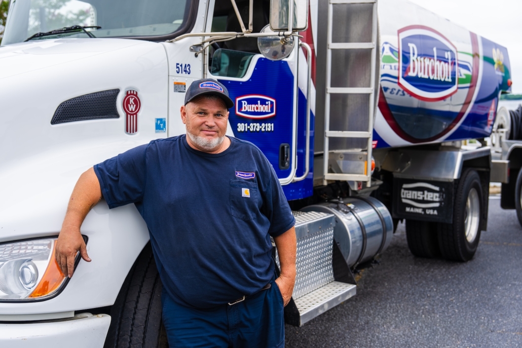 Burch worker smiling and leaning on truck