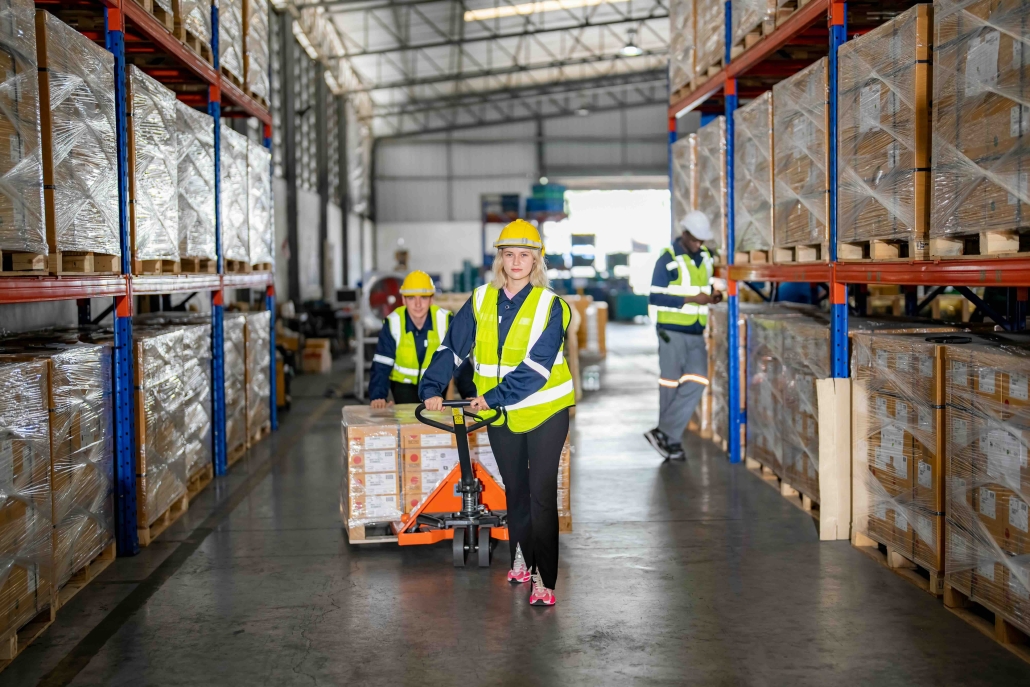 warehouse worker pulling boxes on a wheeled cart